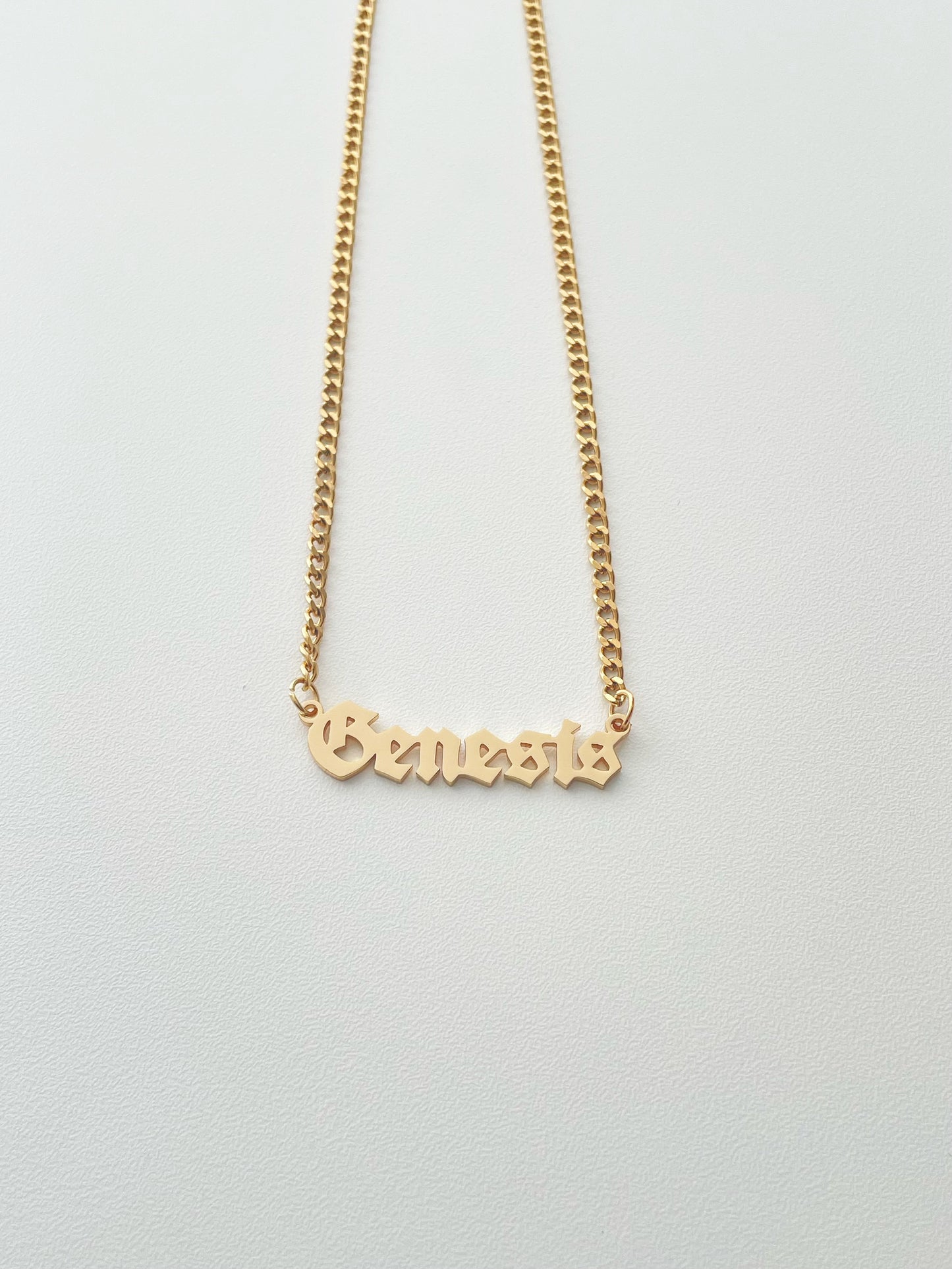 golden Genesis name necklace with goth style font and mini cuba chain