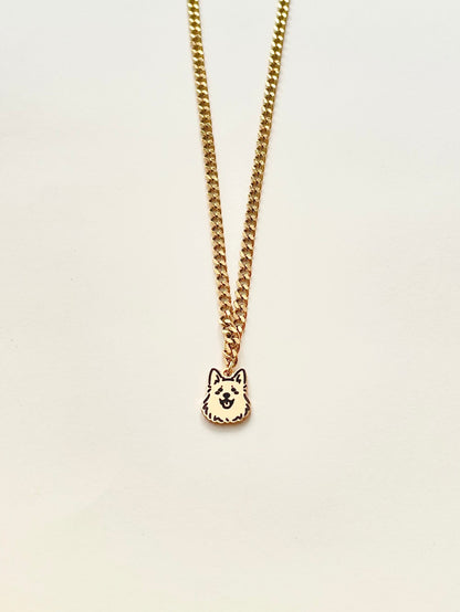 A gold-colored pet avatar necklace on a white background, featuring a small pendant with a cartoon-style design.